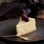 cheesecake facile sans biscuits spéculoos et fourchette sur assiette noire